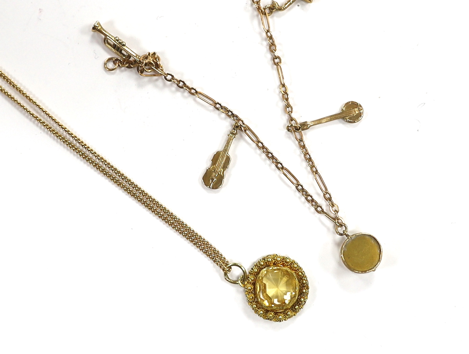 A small 9ct gold charm bracelet, hung with three assorted charms, gross weight 3 grams and a yellow metal and citrine set pendant on a 15ct chain, gross weight 5.5 grams.